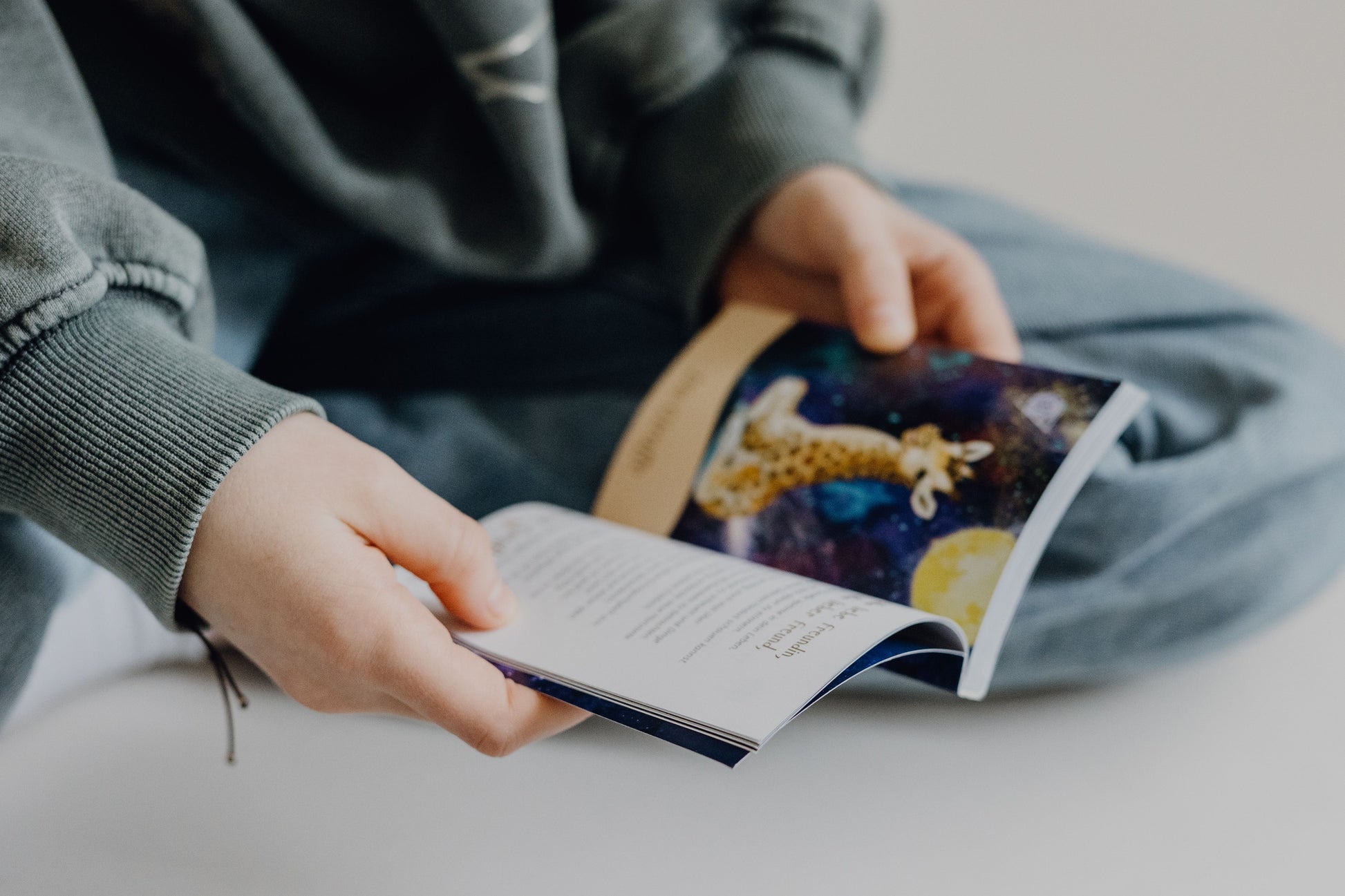 Ein Kind liest aus dem Begleitbuch zu den Krafttierkarten für Kinder und entdeckt die spirituelle Botschaft eines Tieres. Das Buch beinhalten eine persönliche Ansprache, eine Botschaft und eine praktische Übung zur Förderung von Achtsamkeit und Körperbewusstsein. Entwickelt von Physiotherapeutin Jennifer Kühnel, verbindet dieses Set Krafttiere mit physiotherapeutischen Übungen, um die körperliche Entwicklung bei Kindern zu unterstützen.
